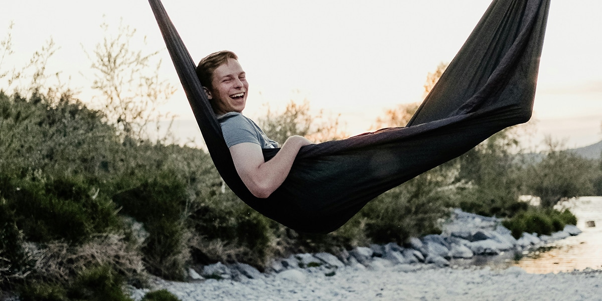 man resting in a hammock in nature