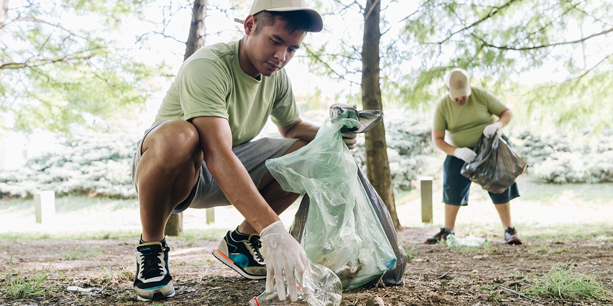 volunteers are picking up trash in a park.