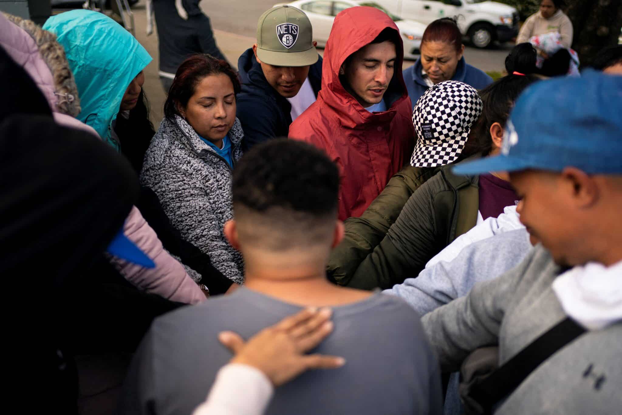 People pray together as a group of mostly Venezuelan migrants camp on the tennis courts of a community center after losing access to other shelter in Seattle April 3, 2024. The bishops of Washington state have affirmed their solidarity with immigrants and refugees, decrying "threats of mass deportations and forced separation of families" that have caused great fear for migrant families, regardless of their migration status. (OSV News photo/David Ryder, Reuters)