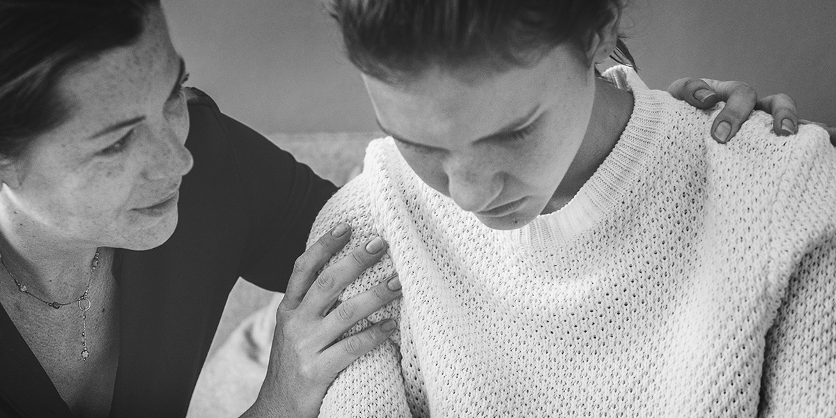 woman showing compassion by comforting younger woman