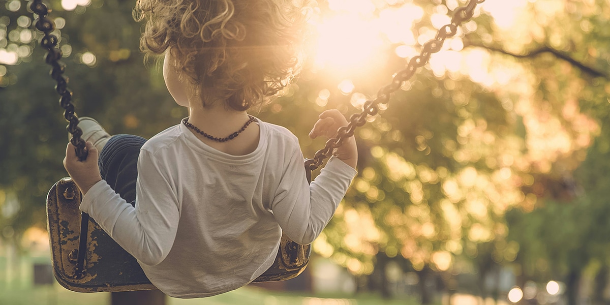 young boy swinging on swings