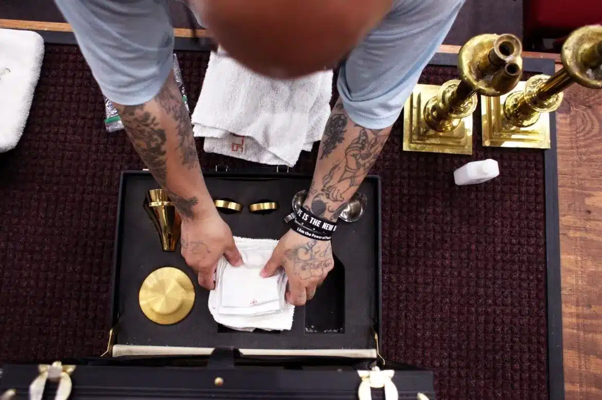 An inmate puts away the items used on the altar following Mass at the Ellsworth Correctional Facility in Kansas. (OSV News photo/Karen Bonar, The Register)