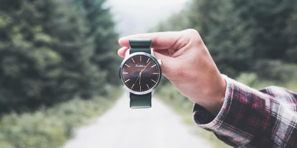 hand holding a watch showing the time.