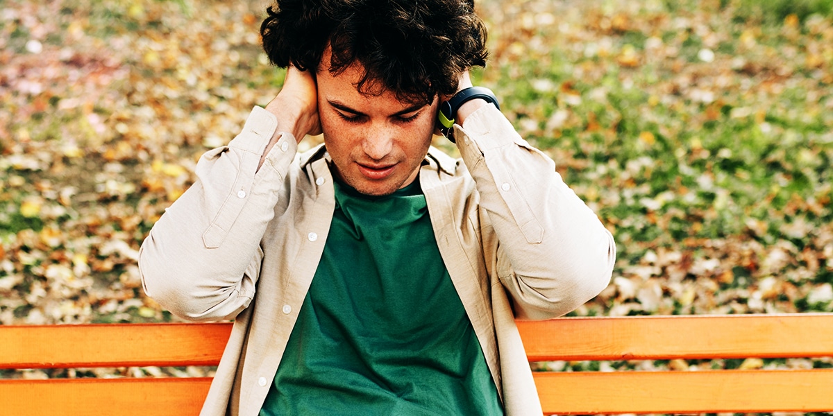 young man holding his ears closed