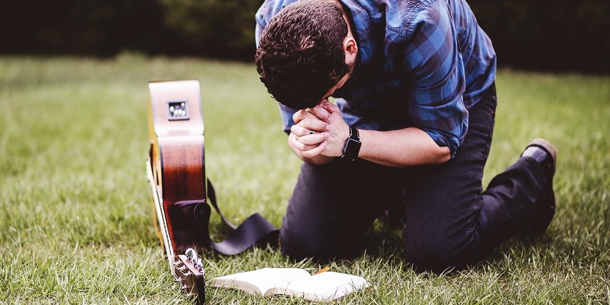 man kneeling while praying