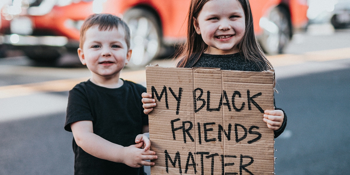 two kids holding a sign with the words: "My Black Friends Matter".