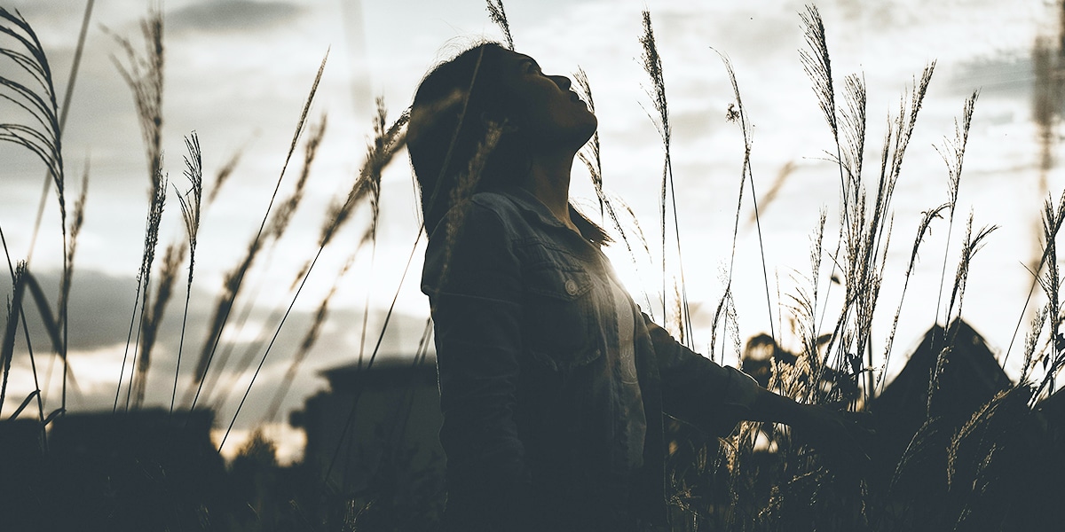 woman praying in a field.