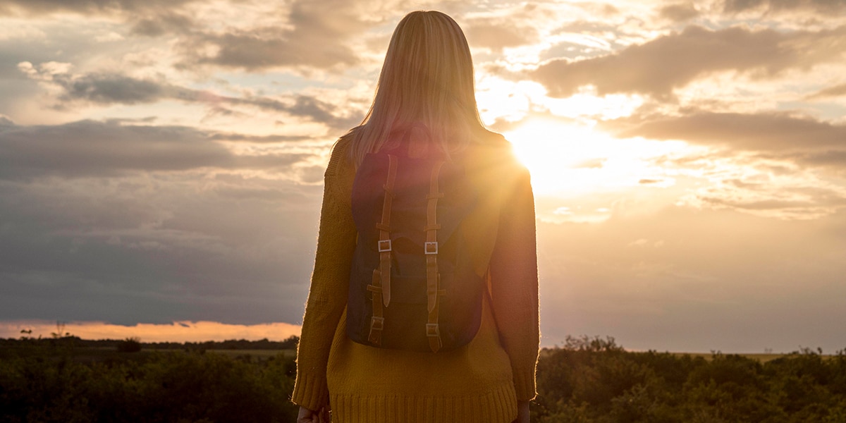 woman reflecting while watching a sunset