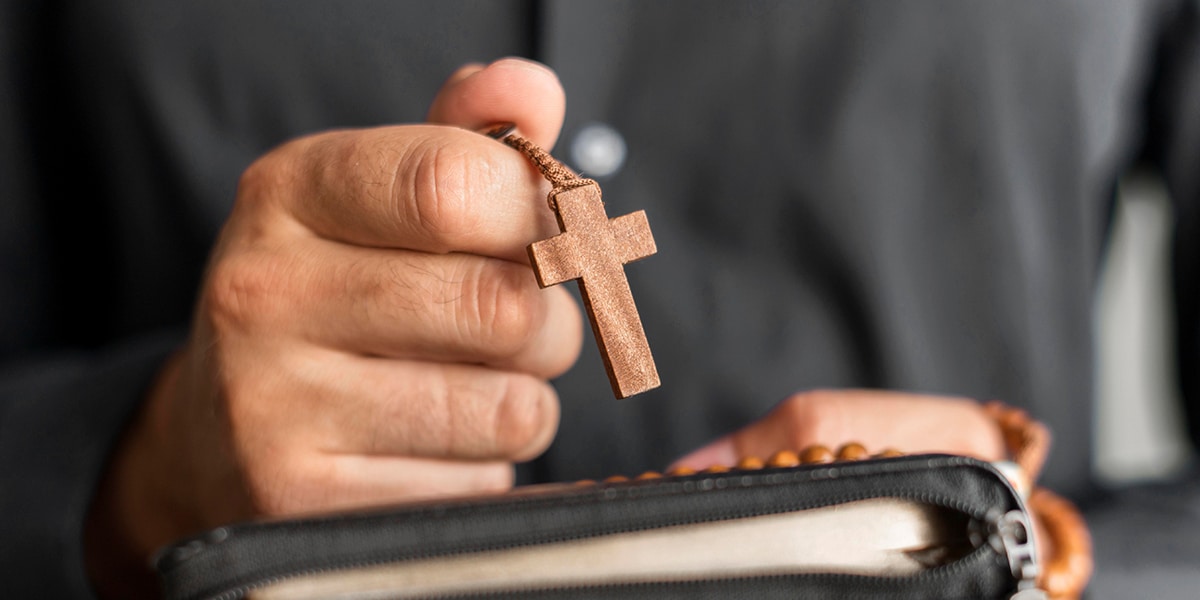 hand holding rosary during prayer