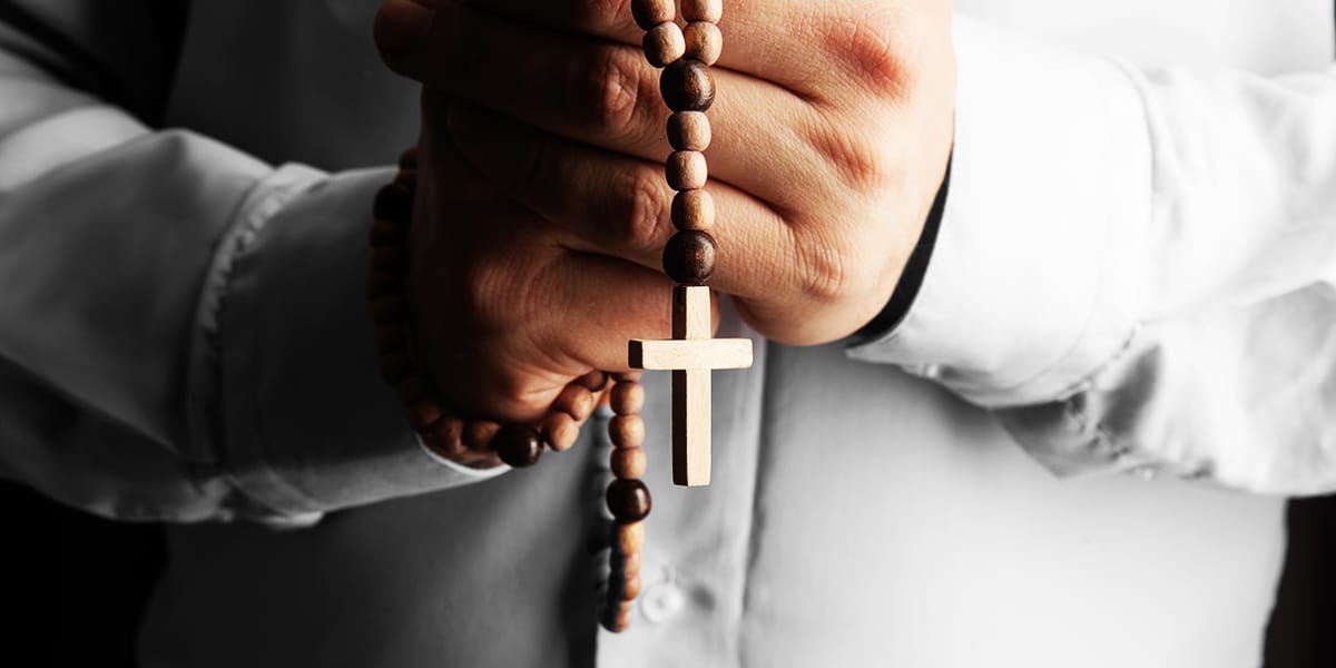 A person praying with a rosary