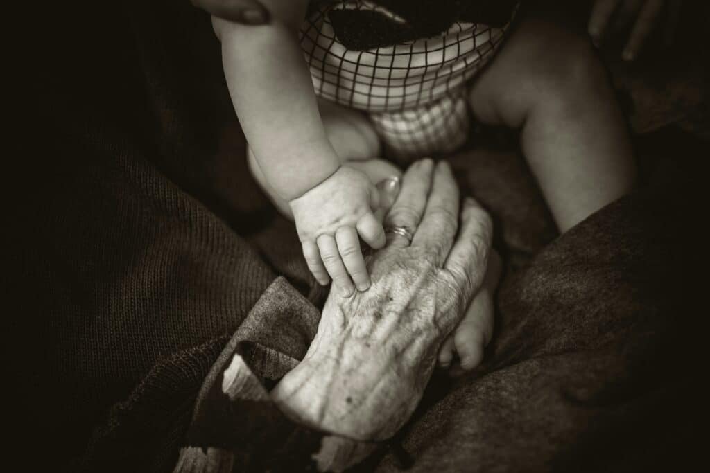 Young hand over a little hand | Rod Long via Unsplash