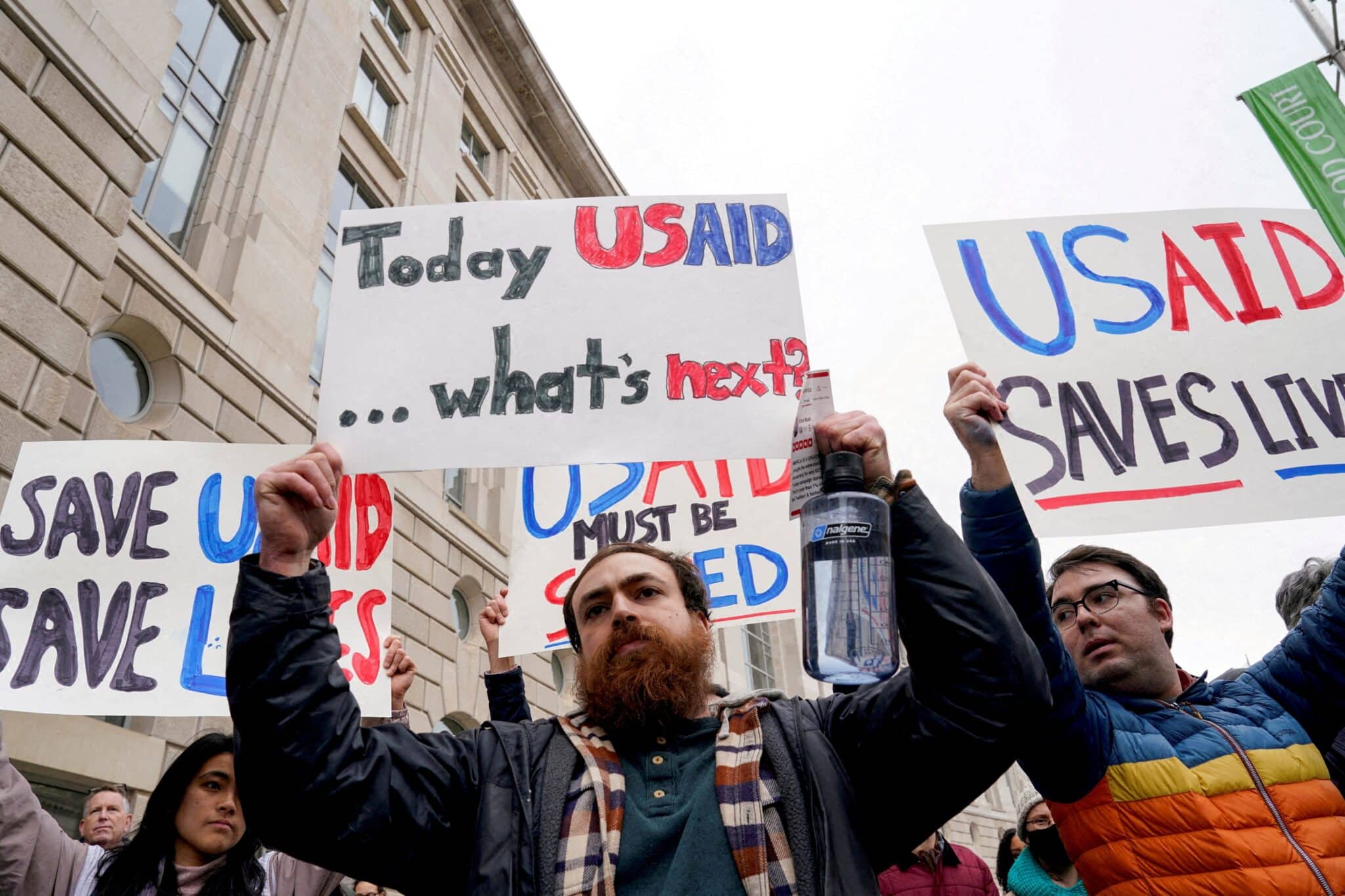 People hold placards outside the U.S. Agency for International Development building in Washington Feb. 3, 2025, protesting the Trump administration's moves to shut down the U.S. foreign aid agency. The Supreme Court on March 5 rejected the Trump administration's request to freeze nearly $2 billion in foreign aid payments, directing the White House to abide by a lower court order. Catholic nongovernmental organizations are among those impacted by the freeze. (OSV News photo/Kent Nishimura, Reuters)