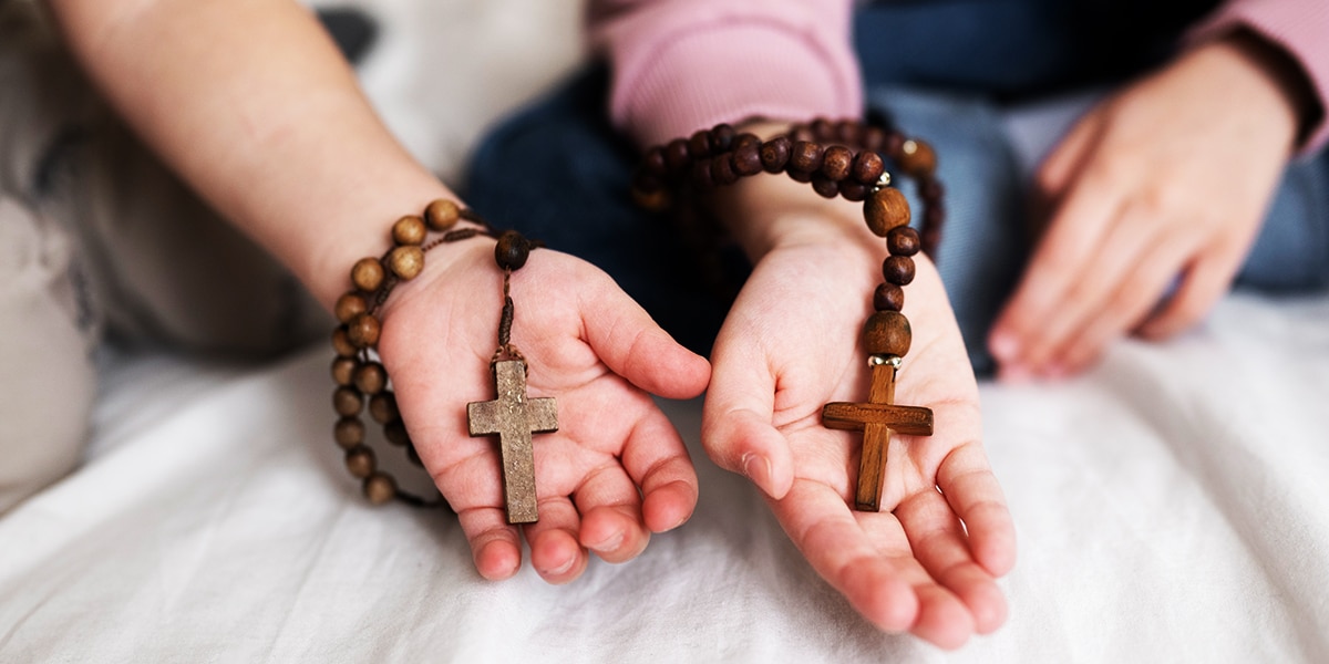 two different hand holding each a rosary