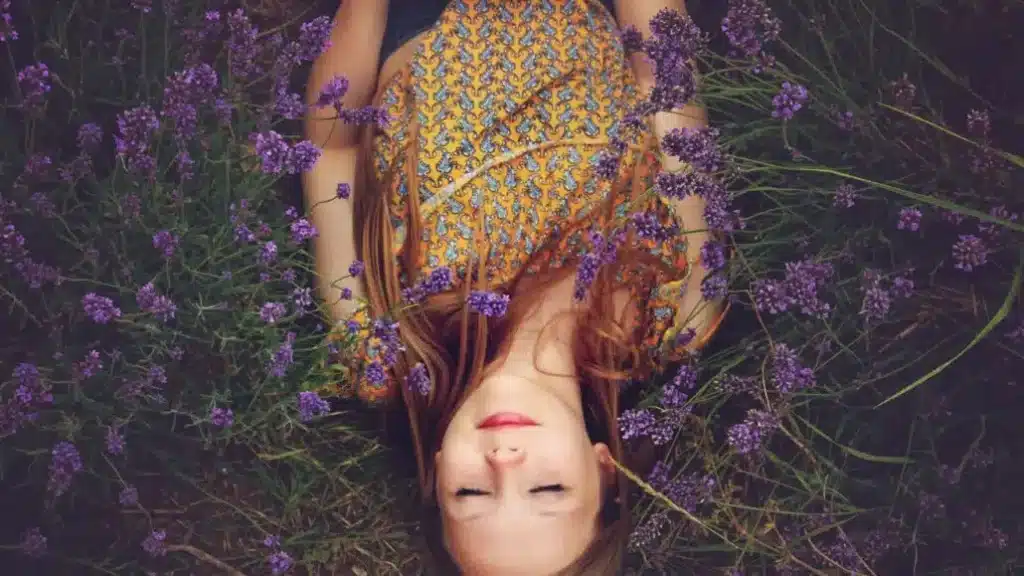 woman sleeping in a field of purple flowers