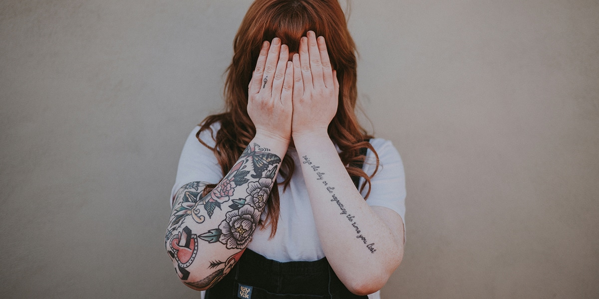 woman covering her face with her hands