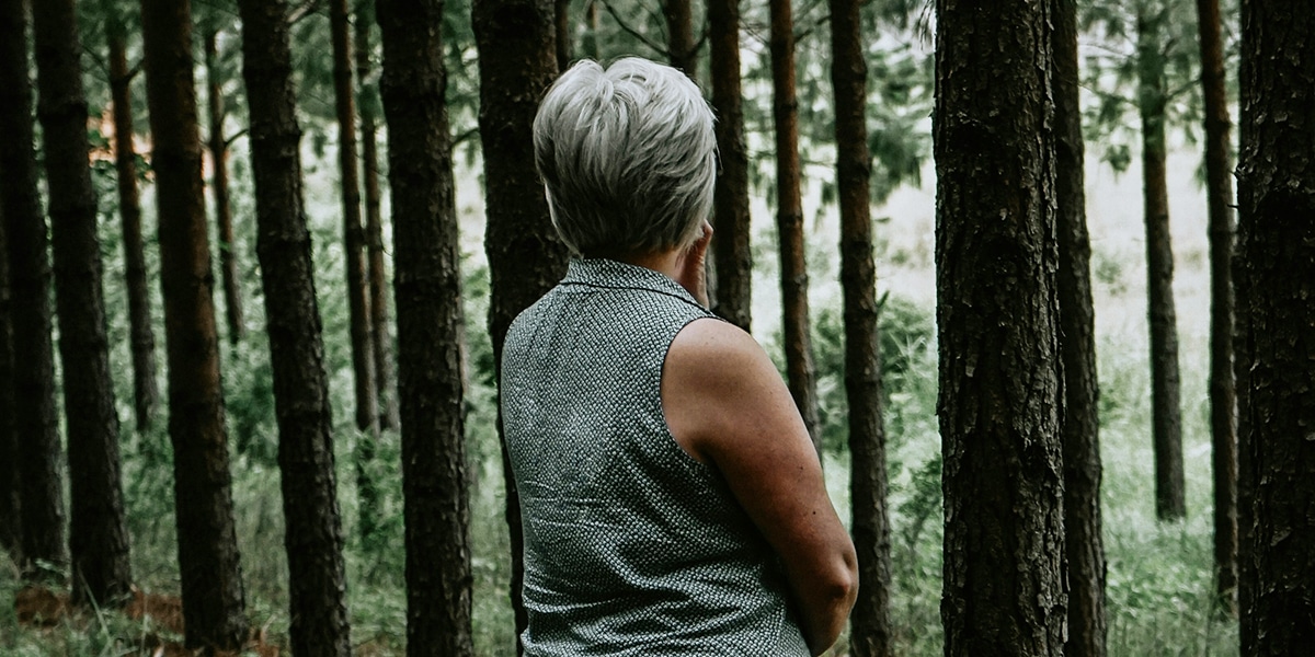 woman standing in a forest and listening to the quietness