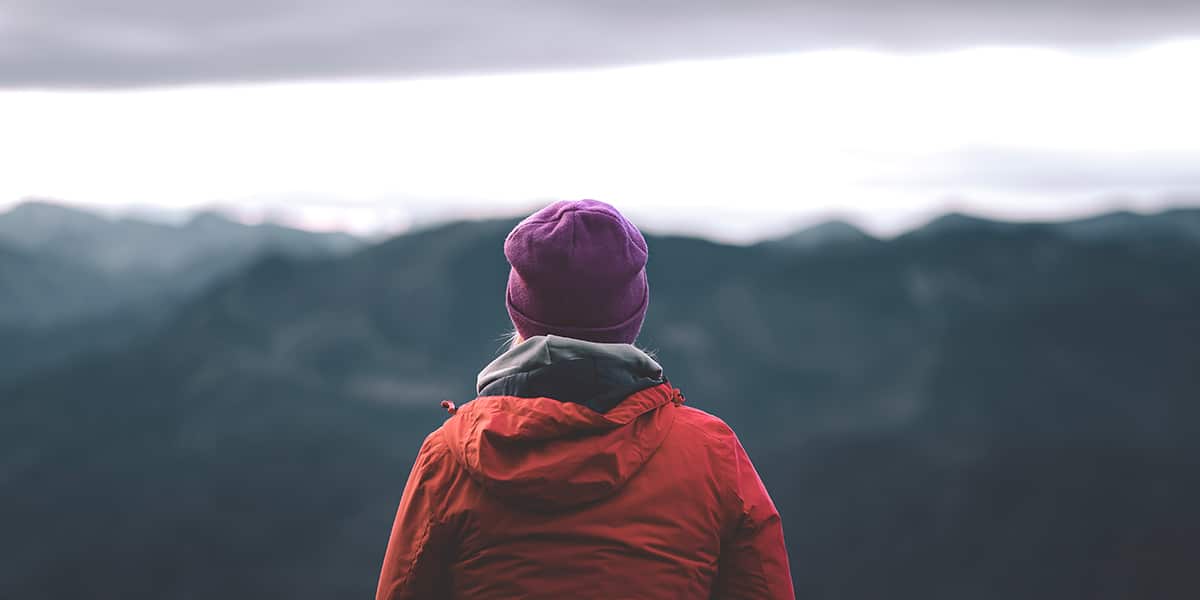 woman standing still in front of mountains